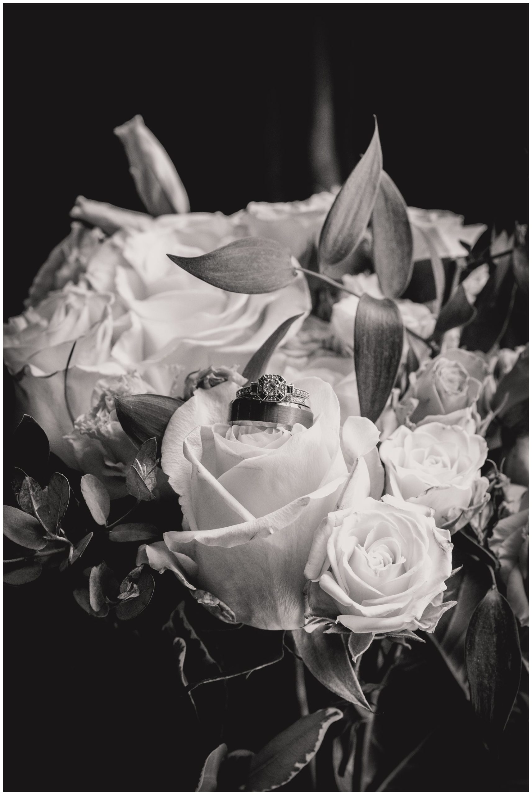 black and white rings resting in wedding bouquet,