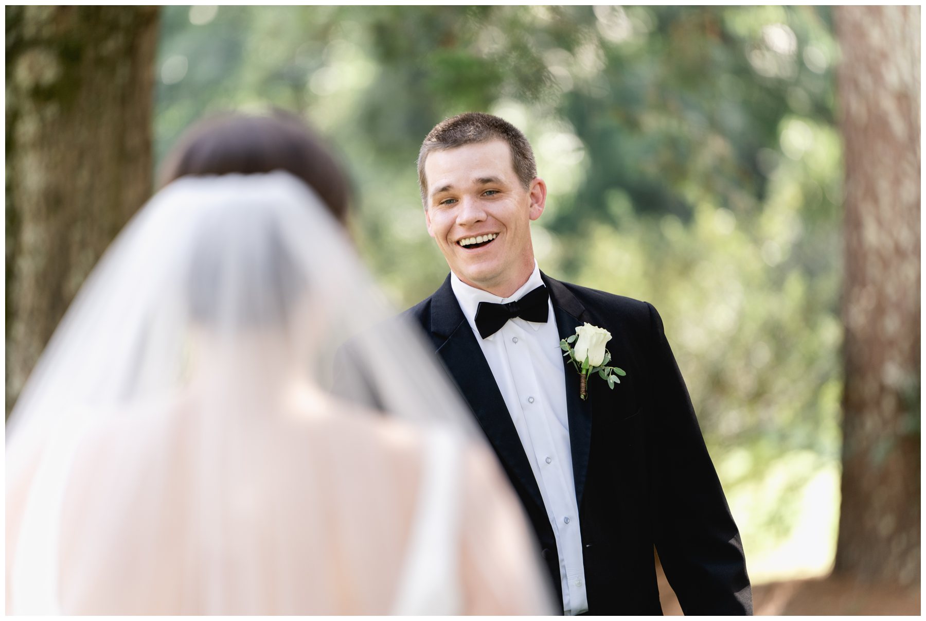 groom first look reaction with white boutonniere,