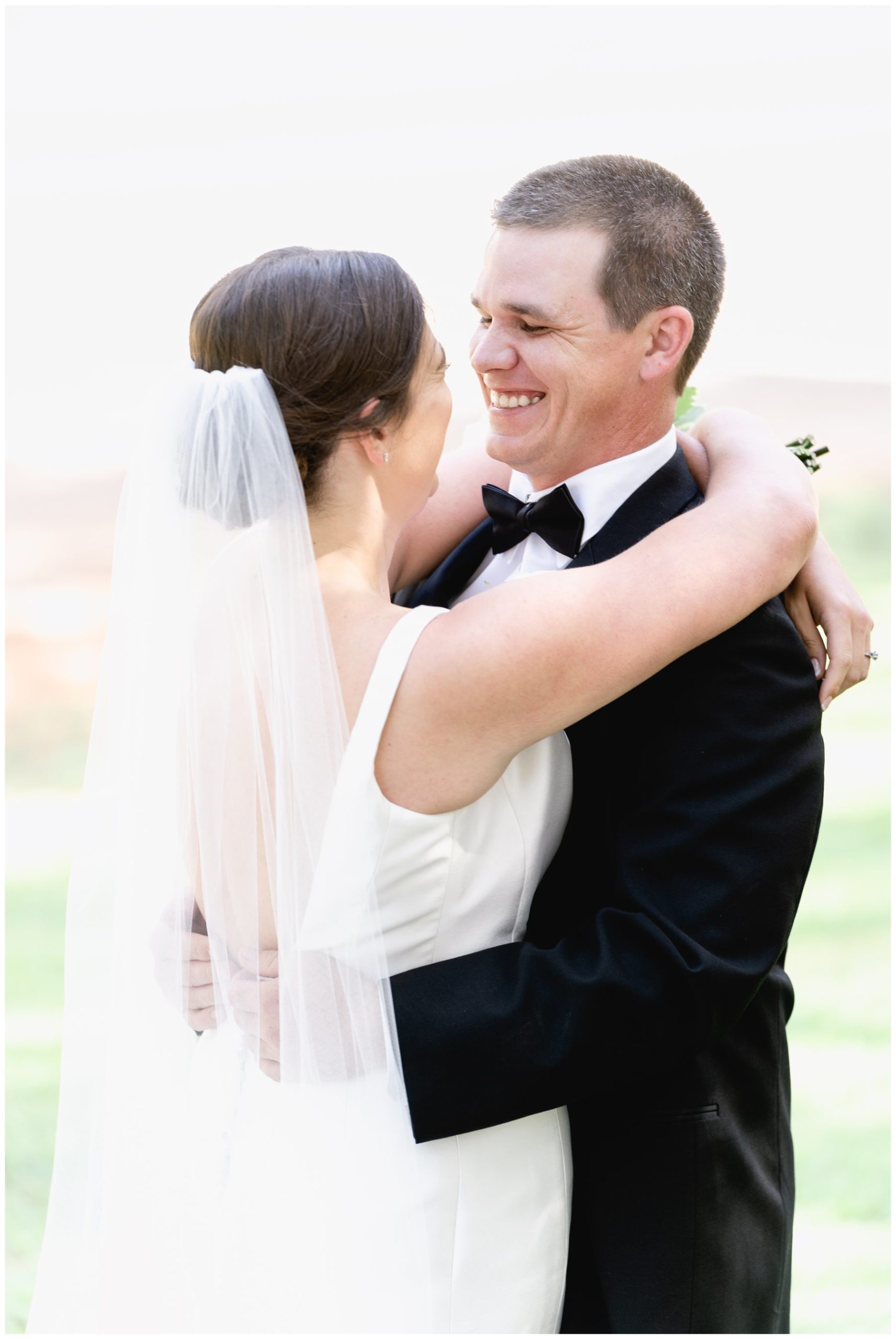 groom smiling at veiled bride,