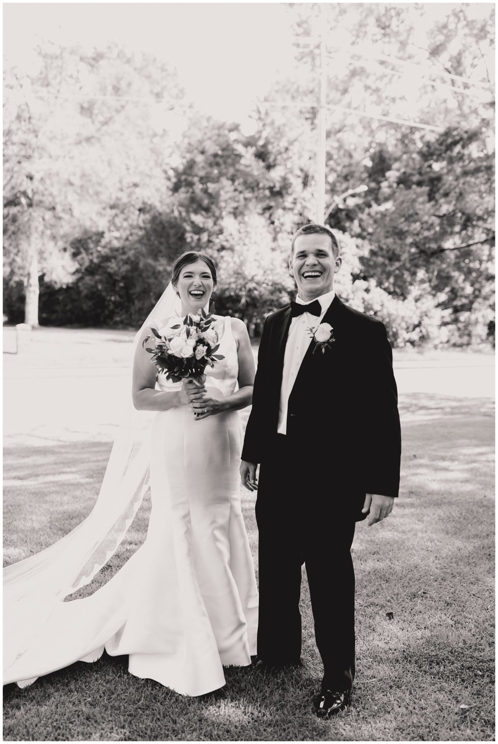 energetic black and white of groom and bride laughing,