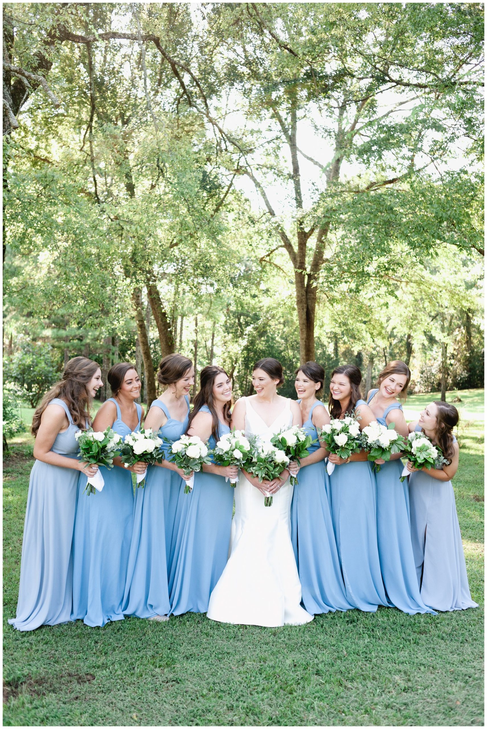 bride and bridesmaids laughing while holding bouquets,