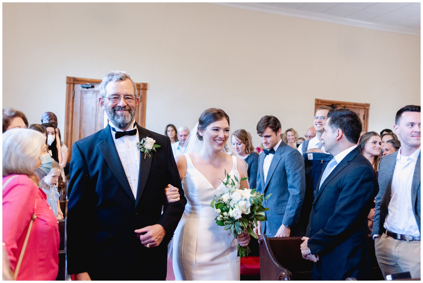 bride and father walking down aisle smiling,